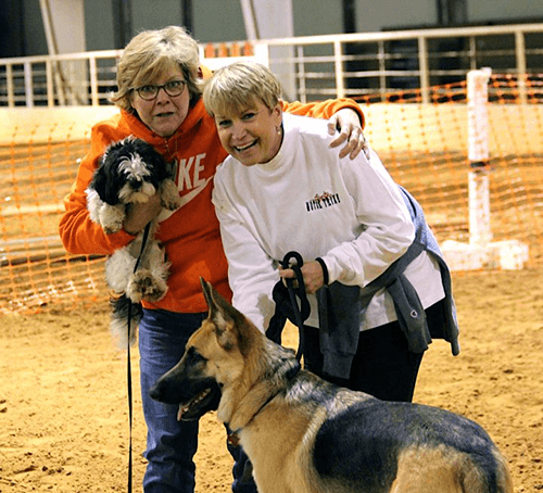 Dog Classs two happy dog owners at a dog training course